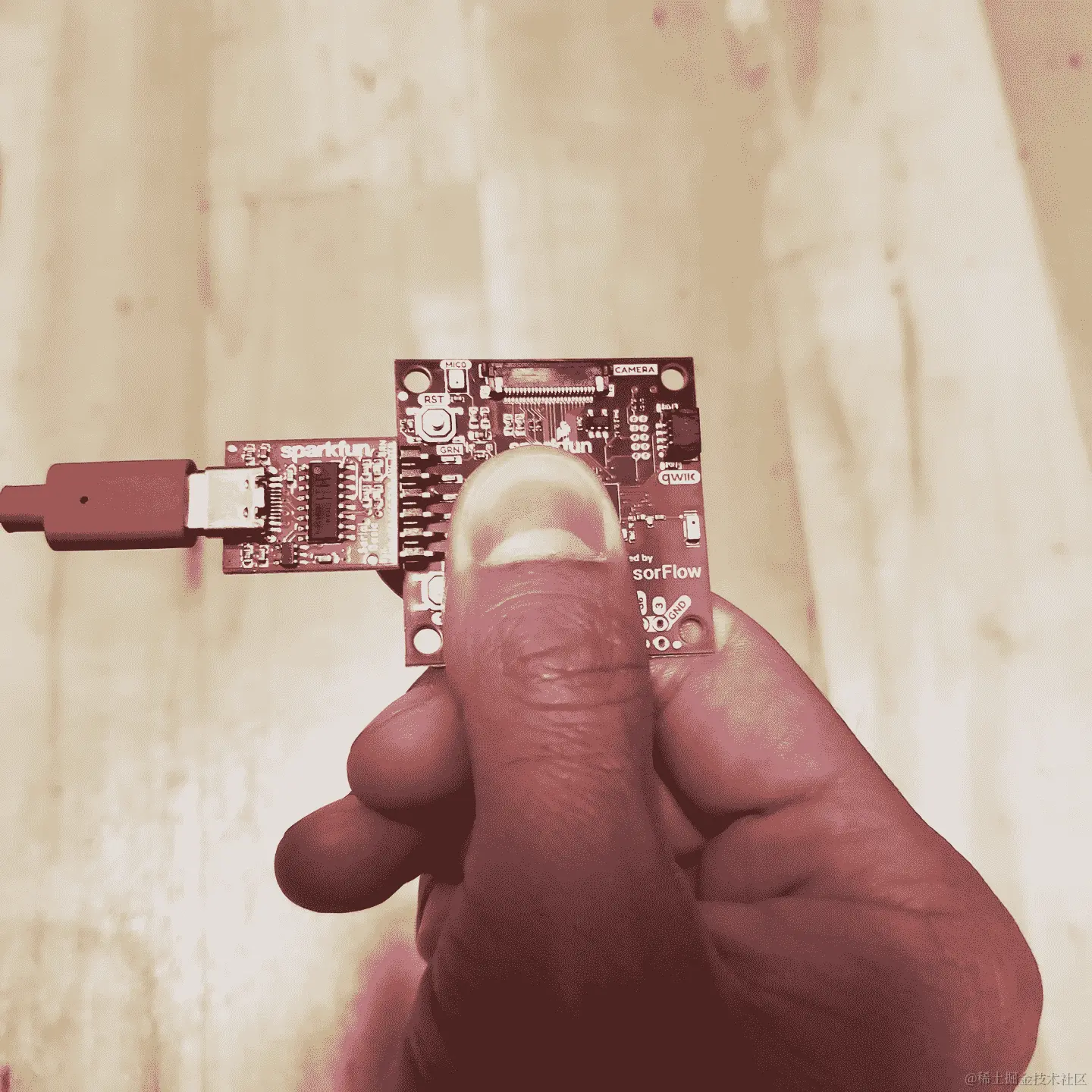 一只手拿着 SparkFun Edge 板子的照片